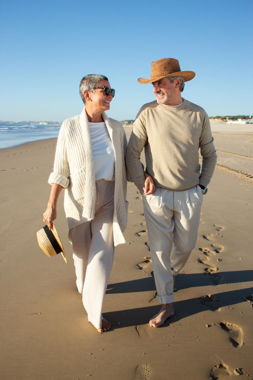 Couple strolling barefoot along beach